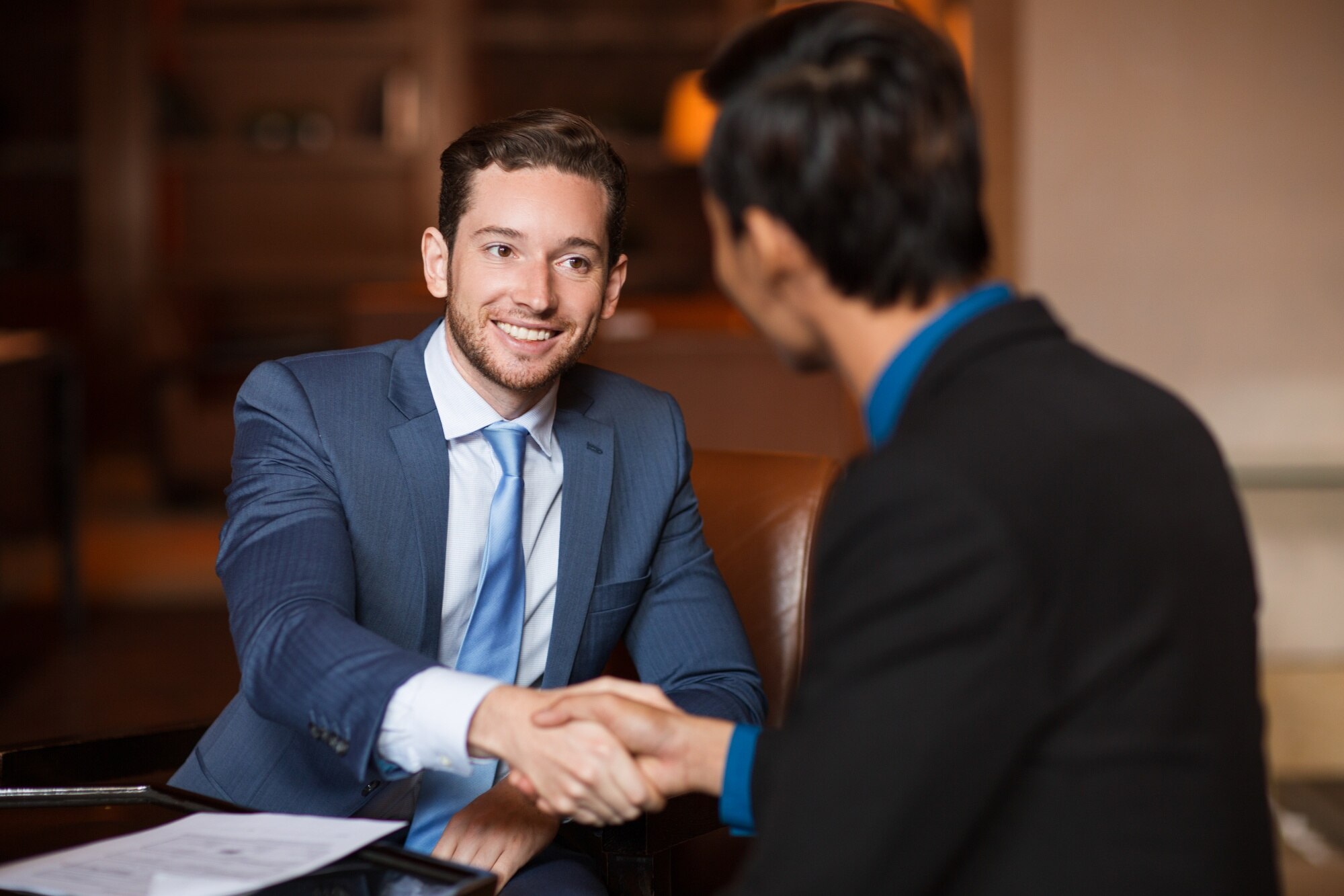 Company head shaking hands with a client, smiling, and ensuring a positive future relationship.